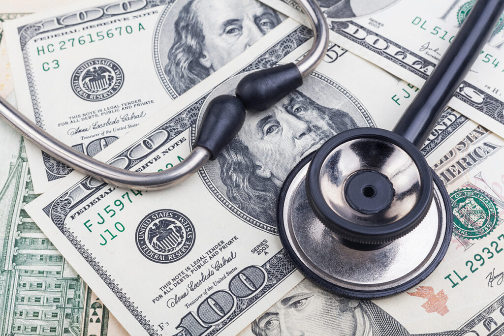 stethoscope on top of cash signifying medical debt