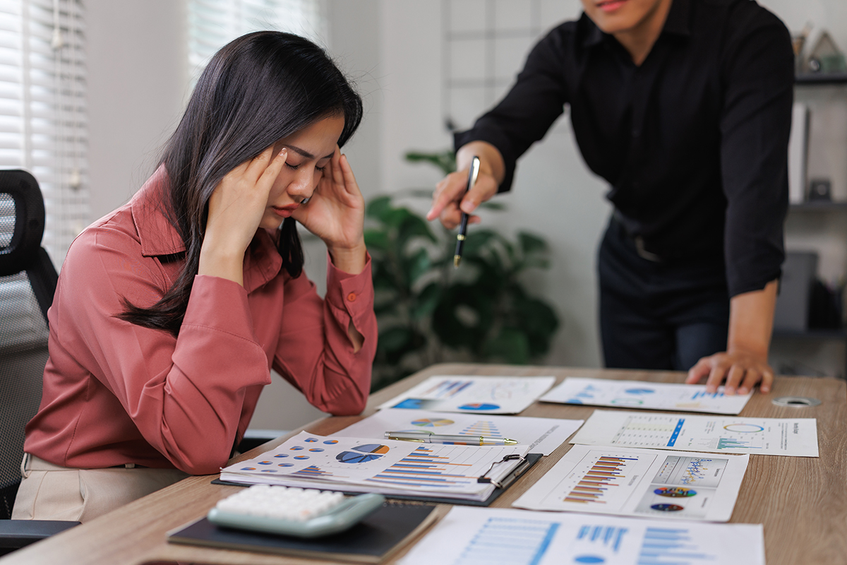 Woman's boss is scolding her at work.