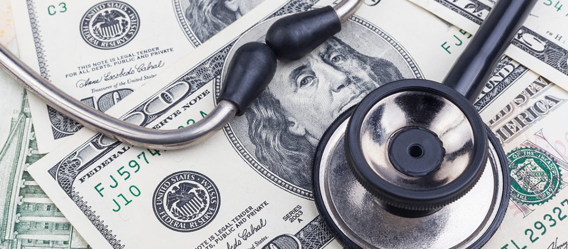 stethoscope on top of cash signifying medical debt